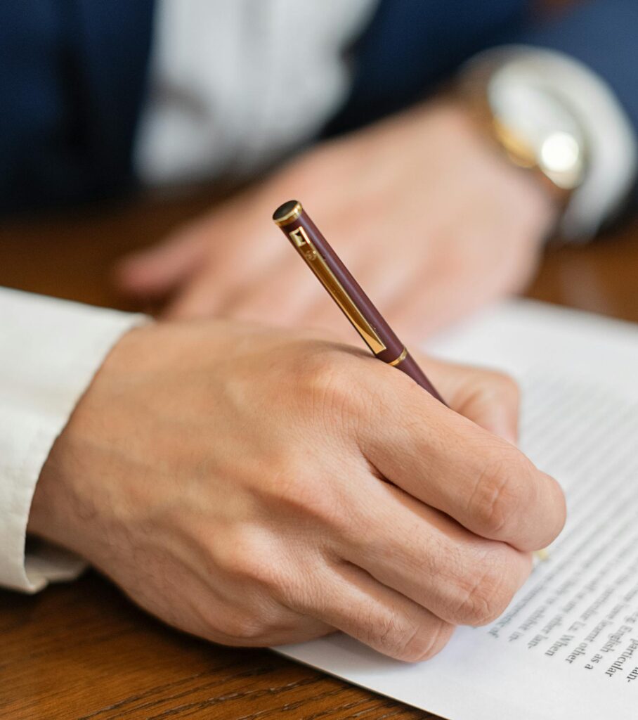 A Person Signing a Document in Close-up Shot